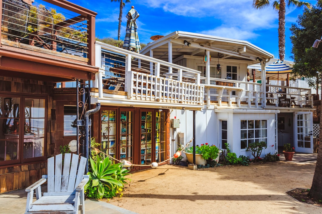 The bright, sunny exterior of a luxurious coastal home with a clean, modern design, representing the high-end real estate market of Wilmington, NC.