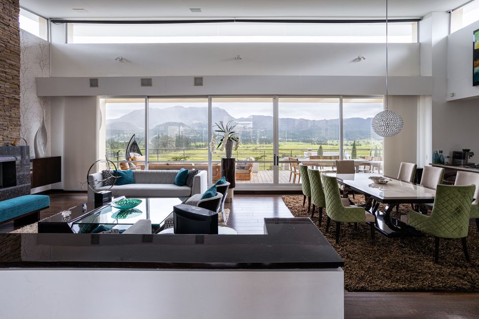 A serene and minimalist luxury living room with floor-to-ceiling windows overlooking a beautiful view, evoking a sense of peace, success, and the financial security achieved from a well-managed home sale.
